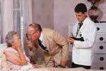 Γιατρός εξετάζει άτομο τρίτης ηλικίας σε κρεββάτι του νοσοκομείου.